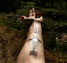 a person's arm with an arrow tattoo on it