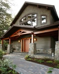 a large house with stone steps leading up to the front door and covered porch area