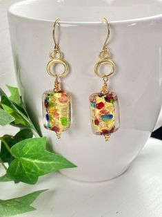 "Bold and beautiful Murano glass with splashes of gold, red, green and blue! These earrings remind me of an artists palette!  Made exclusively by artisans in Murano, Italy...they are THE masters of glass working!  The rectangle glass hangs on Vermeil gold charms of oval circles for fun and whimsy! The earrings hang 2.25- inches on gold Vermeil ear wires. So versatile and easy to wear with any outfit. You will love these earrings. A wonderful gift for any occasion and arrives in a standard gift b Modern Gold Glass Earrings, Unique Gold Glass Earrings, Handmade Multicolor Glass Earrings, Nickel-free Multicolor Glass Earrings, Party Earrings In Multicolor Glass, Multicolor Glass Earrings For Party, Party Glass Multicolor Earrings, Colorful Glass Jewelry For Gifts, Colorful Glass Jewelry As A Gift