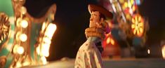 a cartoon character is standing in front of some carnival rides at night with lights on them