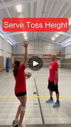 two people are playing with a ball in an indoor basketball court that says serve toss height