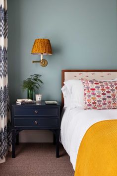 a bedroom with blue walls and yellow bedding