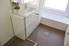 a bathroom with a sink, mirror and bathtub next to a window in it