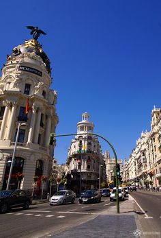 an empty city street with tall buildings on both sides and traffic lights in the middle