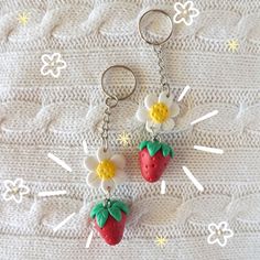 two strawberry shaped key chains with flowers on them