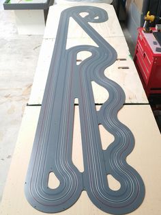 a wooden table topped with a toy race track on top of plywood planks