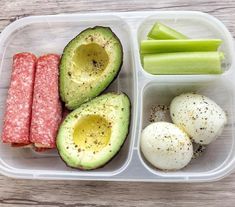 an avocado, egg, sausage and celery in a plastic container