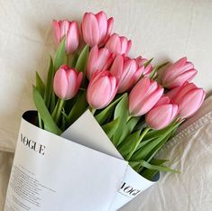 a bouquet of pink tulips sitting on top of a bed