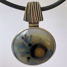 "Zyamara or Mad River Agate and Sterling Silver Pendant * 2 1/2\" x 1 5/8\" pendant. * 4mm black tubing * 19\" long * S hook and 5\" sterling silver extension chain. I was lucky to get this material in 2018 from a gentleman who  gathered the agate from the river basin where the Betsiboka River meets the Indian Ocean in Madagascar.  I had to slab the agate close the surface where the best dendrites seem to form.  It's a long process of rotating and cutting to find the treasure.  This piece was so River Basin, Pretty Mugs, Metal Works, S Hook, A Gentleman, Metal Words, Crazy Lace Agate, Lace Agate, Indian Ocean