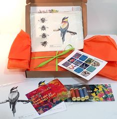 an orange box with some cards and thread on it