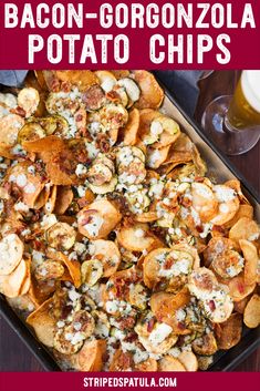 a tray filled with nachos and beer next to two glasses on a table