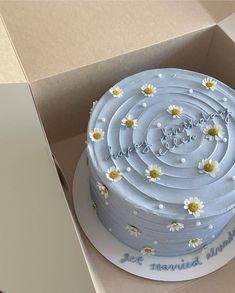 a cake in a box with daisies on it