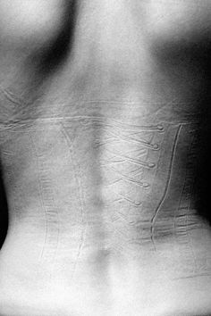 the back of a woman's stomach showing her lower body, with an emblem on it