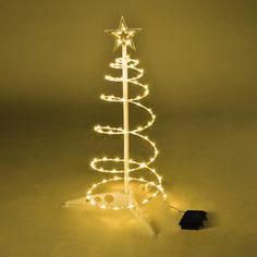 a small christmas tree with lights on it and a black object in the foreground