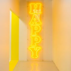 a neon sign that says happy in the middle of a room