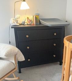 a baby's room with a crib, rocking chair and dresser in it