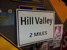 there is a street sign that says hill valley 2 miles on the side of the road