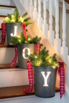 three potted christmas trees with lights on them