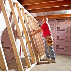 a man standing on top of a wooden floor next to a ladder in a room under construction