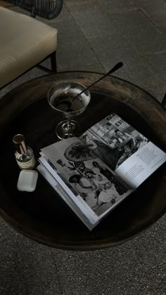 a table that has some books on it and a glass in the middle with a drink