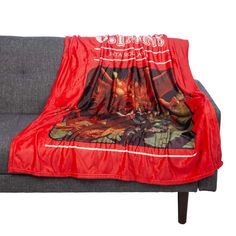 a red blanket sitting on top of a gray couch