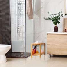 a bathroom with a sink, toilet and shower stall in the corner next to a wooden cabinet