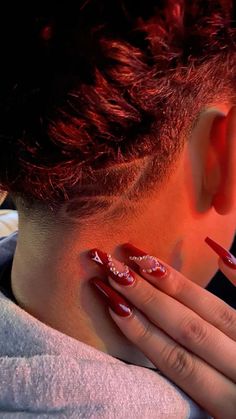 a woman with red nail polish on her face and nails in the shape of hearts