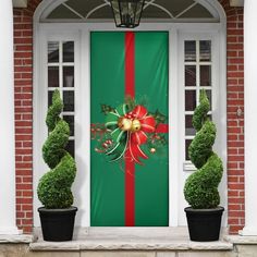 a green door with a red ribbon and christmas decorations on it, next to two black potted plants