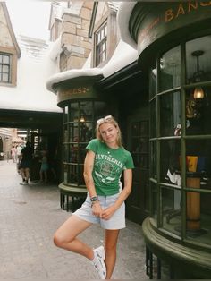 a woman standing in front of a store with her leg up on the window sill