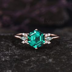 an emerald colored stone surrounded by white diamonds