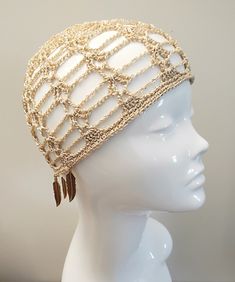 a white mannequin headpiece with gold chains and tassels on it