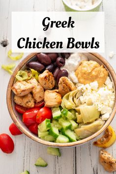 a bowl filled with greek chicken bowls and vegetables