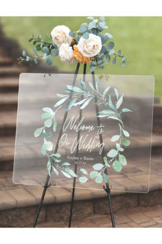 a welcome sign with flowers and greenery in the center on top of a set of steps