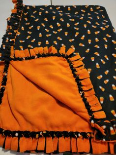 an orange and black blanket laying on top of a table