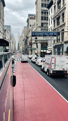 a city street filled with lots of traffic next to tall buildings on either side of the road