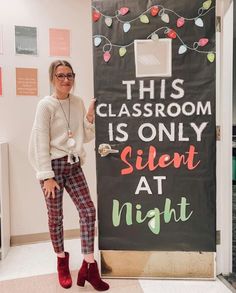 a woman standing next to a sign that says this classroom is only silent at night