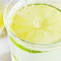 a glass filled with liquid and a slice of lime