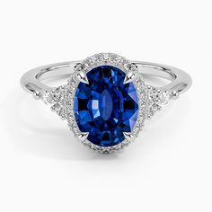 an oval shaped blue sapphire surrounded by white diamond halos and pave set in 18k white gold