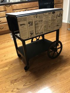 an old newspaper cart with wheels is on the floor in front of a kitchen counter