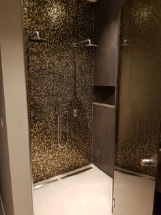 a walk in shower sitting inside of a bathroom next to a tiled wall and floor