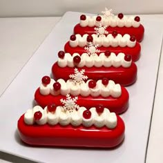 four red and white desserts are arranged in the shape of a christmas tree