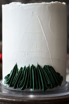 a white cake with green decorations on top