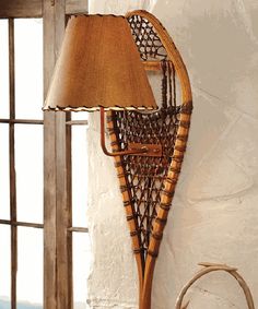 a lamp that is on the side of a wall next to a basket with fruit