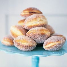 powdered sugar donuts stacked on top of each other on a blue plate with frosting