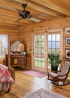 a bedroom with wooden walls and ceiling fan