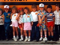 a group of children standing in front of a school bus