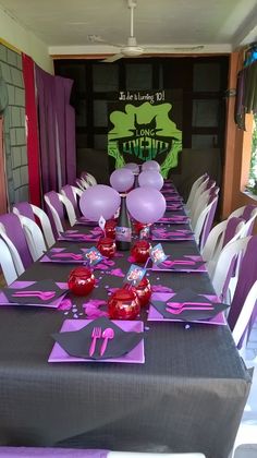 the table is set with purple and pink decorations