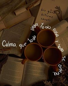 three coffee mugs sitting on top of an open book with the words calma to do today