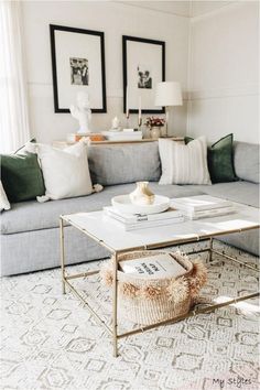 a living room with a couch, coffee table and pictures on the wall above it