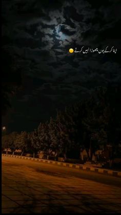 the moon is shining brightly in the night sky over a street with trees and bushes